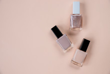 Creative Flat Lay Of Fashion Bright Nail Polishes On A Beige Background. Minimal Style. Copy Space. Beauty Blogger Concept. Top View. Nude Tones.