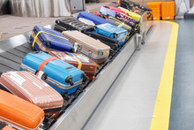 Bright Suitcases And Bags On Luggage Conveyor Belt In Airport