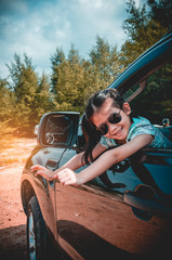 Wall Mural - Asian girl smiling with perfect smile while sitting in the car. Travel on vacation concept.