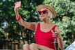 © zinkevych - Photo with martini. Beaming blonde-haired mature woman with bright red lips making photo with martini