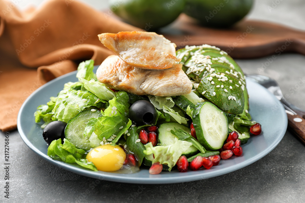 Plate with tasty avocado salad on table