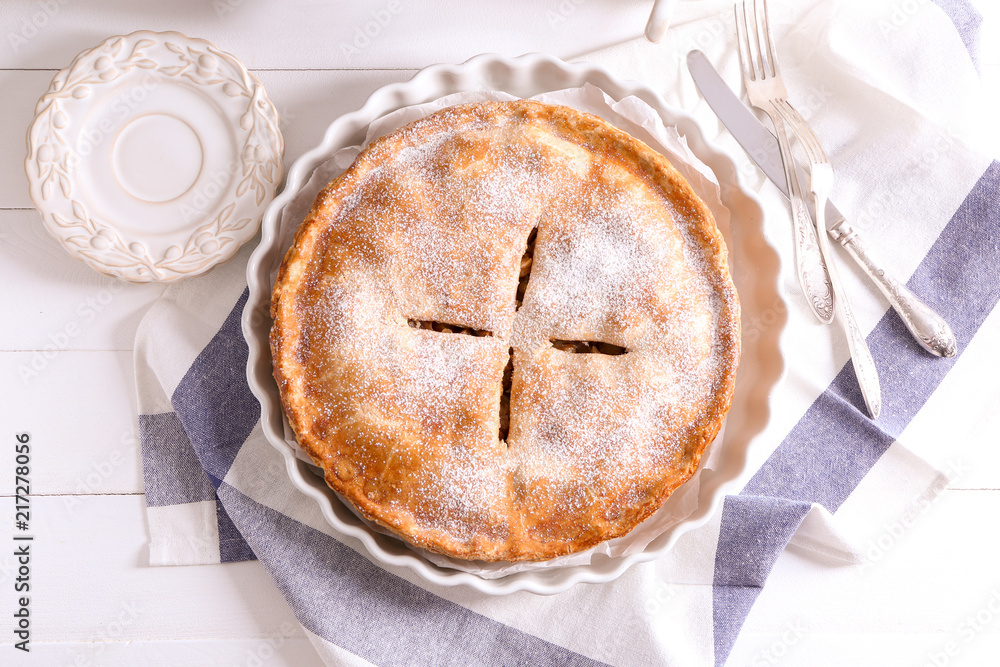 Plate with delicious apple pie on white wooden table