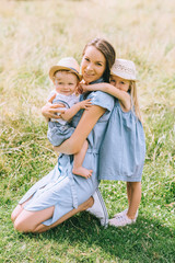 Wall Mural - beautiful mother spending time with children in field