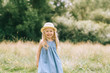 © LIGHTFIELD STUDIOS - adorable blonde smiling child in dress and straw hat in field