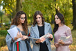 © dobok - three student woman with textbook in a park in autumn