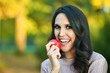 © dobok - young woman eating an apple in a park