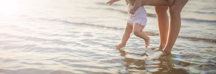 Mother and baby playing with sea waves