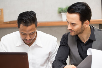 two business Asian man and Caucasian working together discuss and brainstorm to get idea with sale report in office,Teamwork and Business Startup Concept