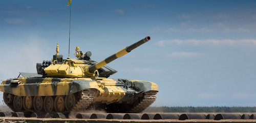 Military or army tank ready to attack and moving over a deserted battle field terrain. a lot of dust. copyspace