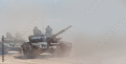 Fotografia Military or army tank ready to attack and moving over a deserted battle field terrain