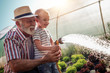 © ivanko80 - Grandfather with his grandson working in the garden