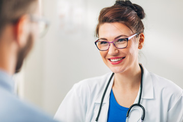 Wall Mural - Woman Doctor talking to Patient at her Medical Office