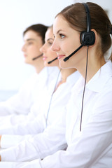 Wall Mural - Call center. Focus on beautiful woman in headset