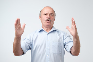 Poster - Handsome mature man gesturing with hands showing big and large size sign, measure symbol.