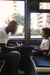 © Angel Ruiz Sanchez - Side view of father tying son's shoelaces while sitting in bus