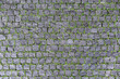 Overhead view of cobblestone street texture with grass . Stone pavement texture
