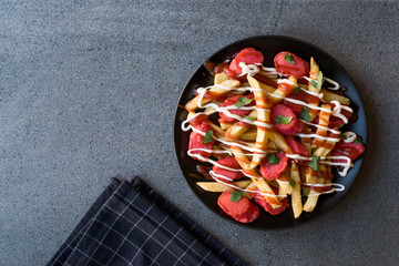 Homemade Peruvian Salchipapa Fries with Sausage Slices, Ketchup and Mayonnaise.