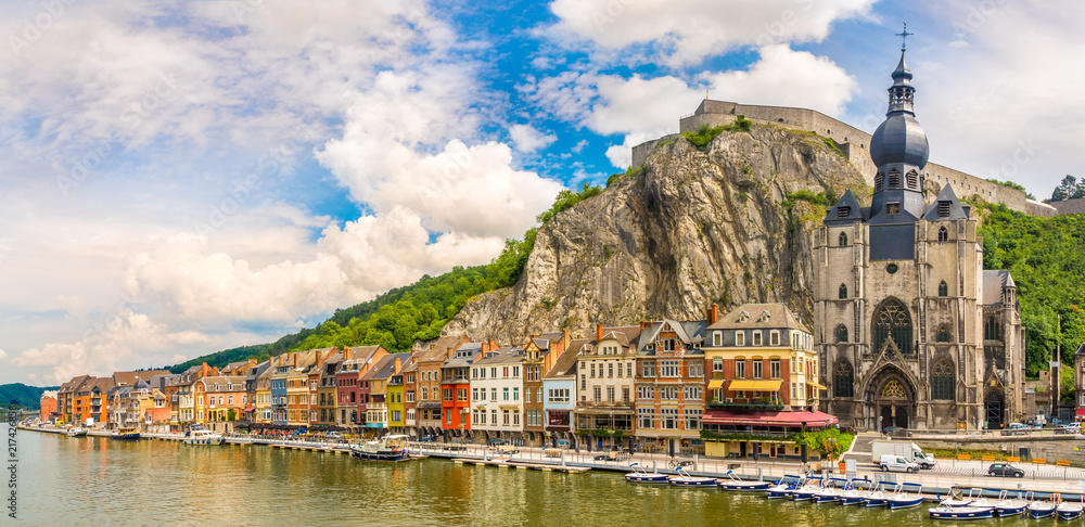 Panoramic vew at the embankment of Meuse river with houses and church of Our Lady Assumption in Dinant - Belgium - obrazy, fototapety, plakaty 