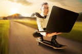 Fototapeta  - Geschäftsmann mit Laptop auf Skateboard