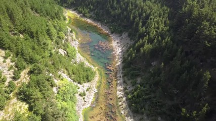 Wall Mural - aerial drone view flying backwards along a lake located inside a steep sided, forested gorge (south 