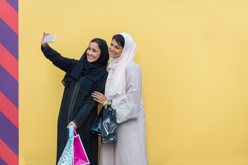 Wall Mural - Two arabian girlfriends bonding and having fun