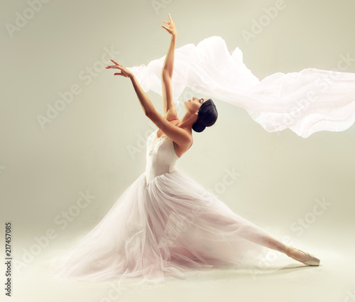 Obraz Dibond Ballerina. Young graceful woman ballet dancer, dressed in professional outfit, shoes and white weightless skirt is demonstrating dancing skill. Beauty of classic ballet.