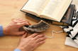 Jewish man hands next to Prayer book, praying, next to tallit. Jewish traditional symbols. Rosh hashanah (jewish New Year holiday), Shabbat and Yom kippur concept.