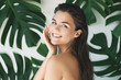 Leinwandbild Motiv Portrait of young and beautiful woman with perfect smooth skin in tropical leaves