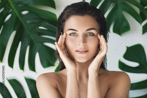 Cuadros en Lienzo Portrait of young and beautiful woman with perfect smooth skin in tropical leave