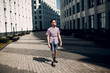© primipil - Disabled young man with foot prosthesis walks along the street.