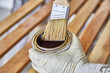Paint Brush in a can of varnish in preparation to stain the wood slats
