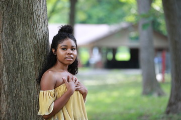 Wall Mural - Black woman leaning on trunk in park