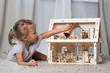 © Evgenia Tiplyashina - a girl playing with a dollhouse