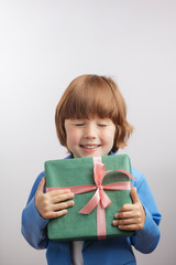 awesome boy with closed eyes is going to give the present to mommy, daddy