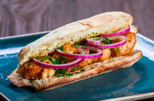 Grilled Chicken In Sandwich From Fresh Pita Bread With Onion And Greens On Dark Wooden Background. Shashlik Or Shish Kebab