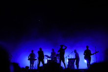 Music Band Playing On Concert Stage, Silhouettes Of Musicians Unrecognizable, Group Of People Singing Together In Rock Festival