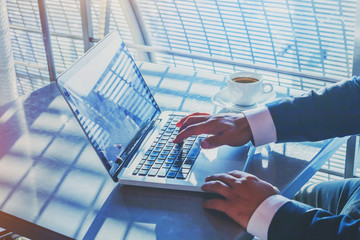 businessman working on computer in airport, banking online on internet, writing email, hands typing on keyboard