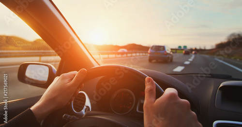 Fotografía hands of car driver on steering wheel, road trip, driving on highway road