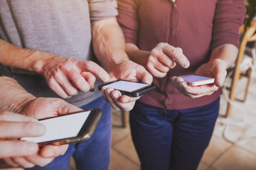 hands of group of people coworkers using smartphones, mobile online communication or social network concept