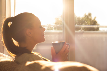 girl enjoying morning coffee in living room