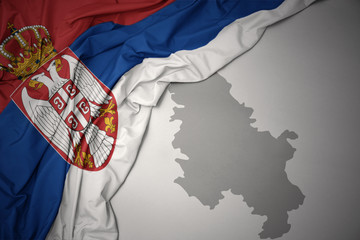 waving colorful national flag and map of serbia.