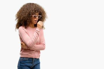 Sticker - African american woman wearing pink sunglasses feeling unwell and coughing as symptom for cold or bronchitis. Healthcare concept.