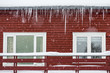 Typical traditional arctic red house with snow and icicle