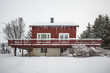 Typical traditional arctic red house with snow and icicle