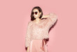 © Sergey Chumakov - fashion woman in pink clothes and sunglasses looking away isolated on pink background