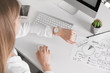 © New Africa - Young woman checking time on her wristwatch at workplace