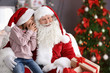 © New Africa - Little girl whispering in authentic Santa Claus' ear indoors