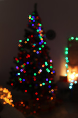 Wall Mural - Blurred view of stylish living room interior with Christmas tree and fairy lights at night