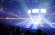 Concert stage with shining lights and crowd at a performance. Rock music event at a stadium with colorful spotlights and projectors.
