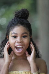 Wall Mural - Surprised young black woman in park